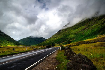 narrow road near grass and mountain narrow road near grass and mountain