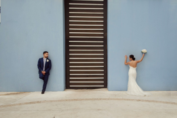 Newlyweds Leaning On Blue Wall Newlyweds Leaning On Blue Wall