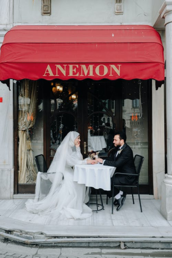 Newlyweds Sitting Together Outside a Cafe Holding Hands on Table · Free Stock Photo