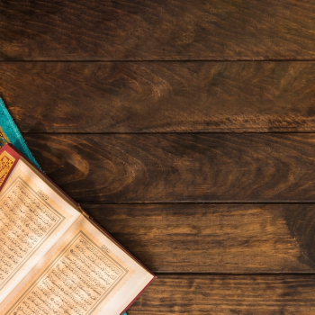Opened Quran on timber tabletop Opened Quran on timber tabletop