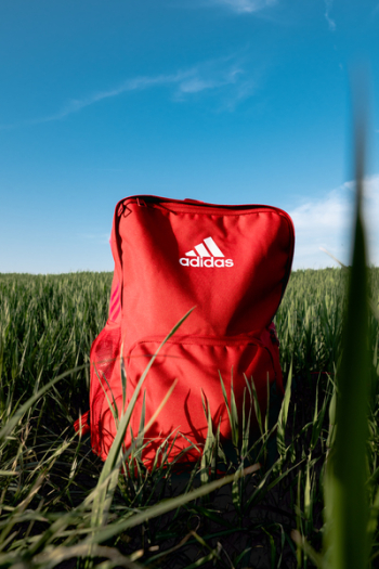 Orange Adidas Backpack On Grass Field Orange Adidas Backpack On Grass Field