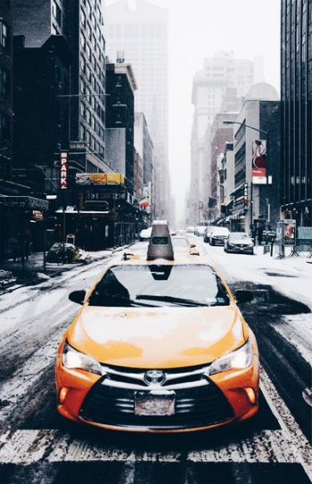 orange Toyota car on road near buildings orange Toyota car on road near buildings