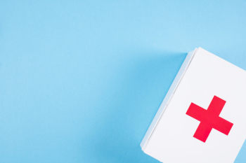 Overhead view of white first aid kit on blue backdrop Overhead view of white first aid kit on blue backdrop
