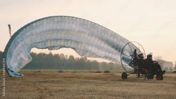 Paramotorgliding. Successfully landed, glider untying parachutist. High quality photo