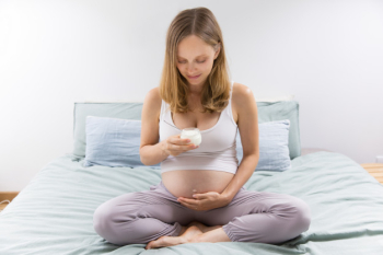 Pensive expectant mother eating yogurt in bedroom Free Photo