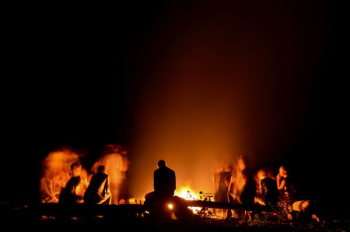 people gathered around camp fire at nighttime people gathered around camp fire at nighttime