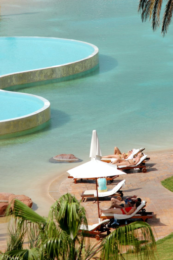 People on Sun Loungers on a Tropical Beach People on Sun Loungers on a Tropical Beach