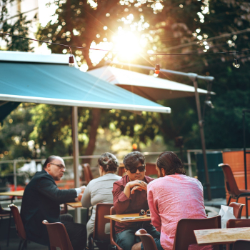 People Sitting on Brown Chairs Under Canopy People Sitting on Brown Chairs Under Canopy