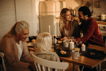 People Sitting on Chairs by the Dining Table People Sitting on Chairs by the Dining Table