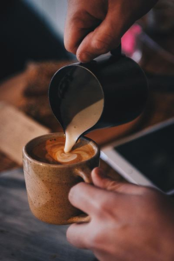 people transferring brown liquid to brown teacup people transferring brown liquid to brown teacup