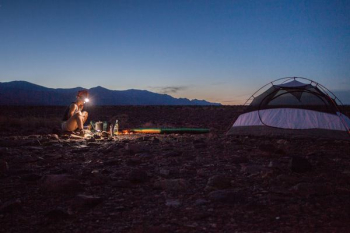 person camping beside white and black tent person camping beside white and black tent