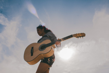 Person Carrying Brown Acoustic Guitar Person Carrying Brown Acoustic Guitar