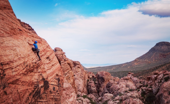 Person Climbing on Brown Mountain Person Climbing on Brown Mountain