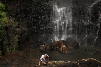 person climbing on rock near water fall person climbing on rock near water fall