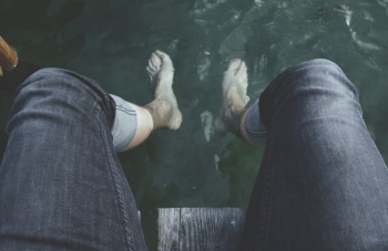 person dangling feet on water person dangling feet on water