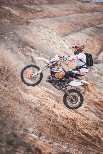 Person Driving Motocross Dirt Bike Outdoors Person Driving Motocross Dirt Bike Outdoors