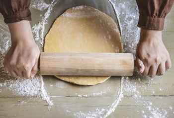 Person Flattening Dough With Rolling Pin