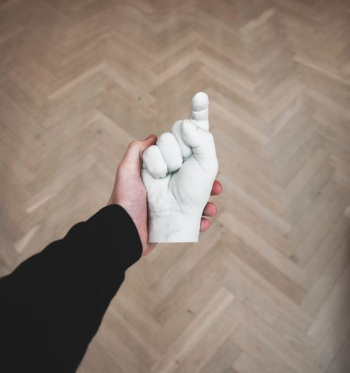 person hand holding hand figurine person hand holding hand figurine