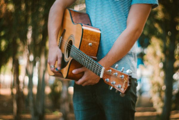 person holding acoustic guitar person holding acoustic guitar