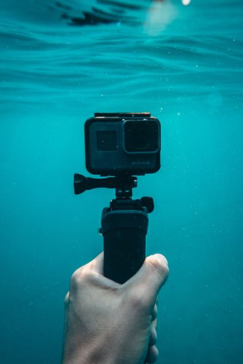 person holding action camera in underwater person holding action camera in underwater