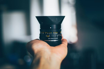 person holding black DSLR camera lens person holding black DSLR camera lens
