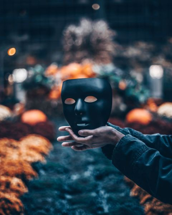 person holding black mask person holding black mask