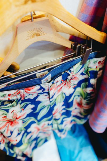 person holding blue and pink floral shorts person holding blue and pink floral shorts
