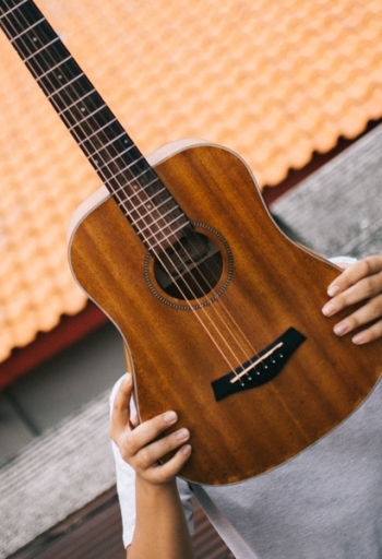 Person Holding Brown Acoustic Guitar Person Holding Brown Acoustic Guitar