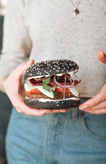 person holding burger person holding burger