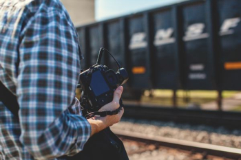 person holding DSLR camera near cargo container during daytime person holding DSLR camera near cargo container during daytime