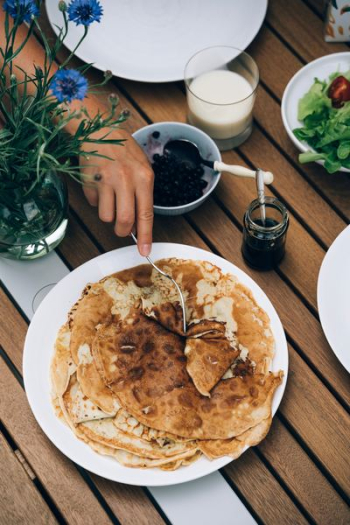 person holding fork on pancake person holding fork on pancake