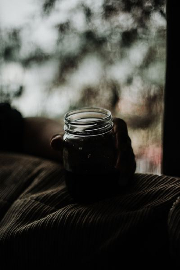 person holding glass jar person holding glass jar