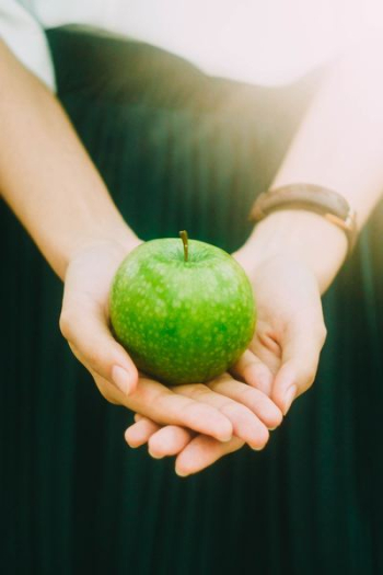 person holding green apple person holding green apple