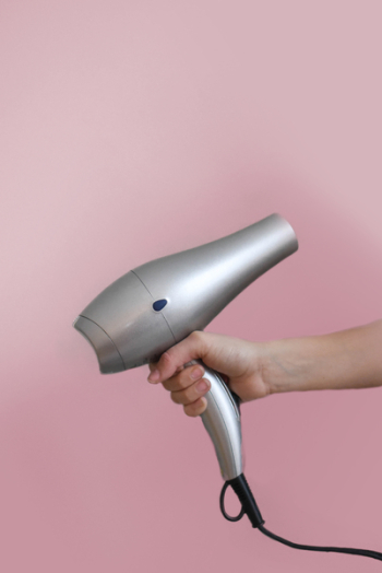 Person Holding Grey Hair Dryer Person Holding Grey Hair Dryer