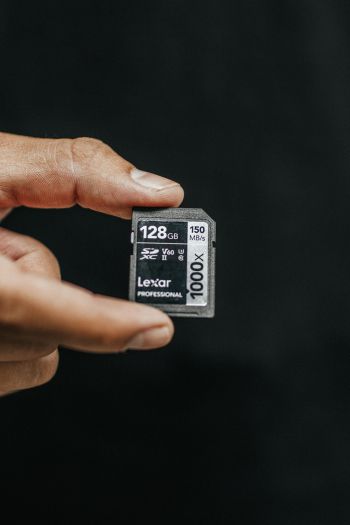 Person Holding Lexar 128gb Sd Card Person Holding Lexar 128gb Sd Card