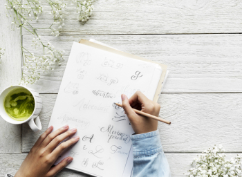 Person Holding Pencil Writing On a Paper