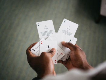 person holding playing cards person holding playing cards