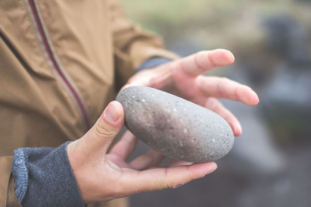 person holding river rock person holding river rock