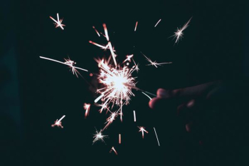 person holding sparkling light person holding sparkling light