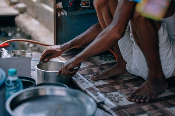 person holding stainless steel cooking pot person holding stainless steel cooking pot