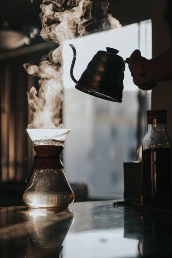 person holding teapot with boiled water person holding teapot with boiled water