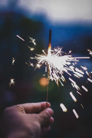Person Holds Lighted Sparkler Person Holds Lighted Sparkler