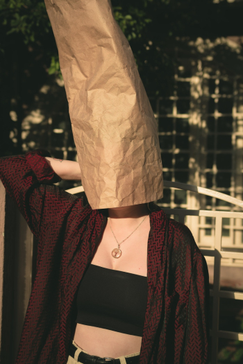 Person In Black Tube Top Covering Head With Paper Bag Person In Black Tube Top Covering Head With Paper Bag