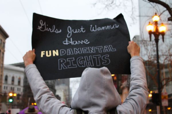 person in gray hooded jacket holding black sign person in gray hooded jacket holding black sign