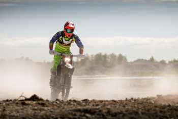 Person In Green Motocross Gear Riding A Dirt Bike Person In Green Motocross Gear Riding A Dirt Bike