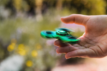 Person Playing With Green Fidget Spinner Person Playing With Green Fidget Spinner