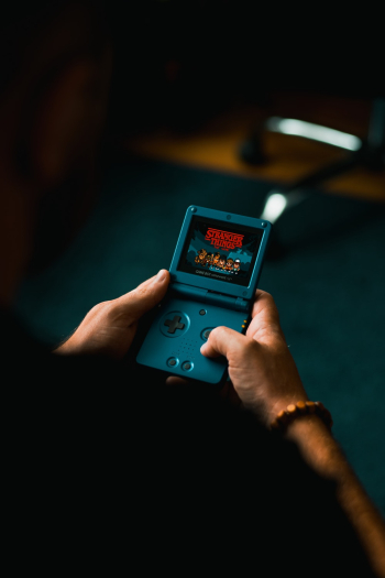 Person Playing With Handheld Game Console Person Playing With Handheld Game Console