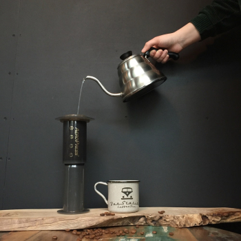 Person Pouring Liquid on Black and Brown Container Person Pouring Liquid on Black and Brown Container