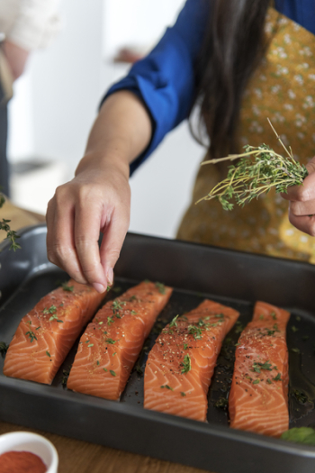 Person Pouring Seasonings on Raw Meats Person Pouring Seasonings on Raw Meats