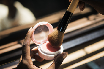 Person Putting Makeup Brush on Blush Powder Container